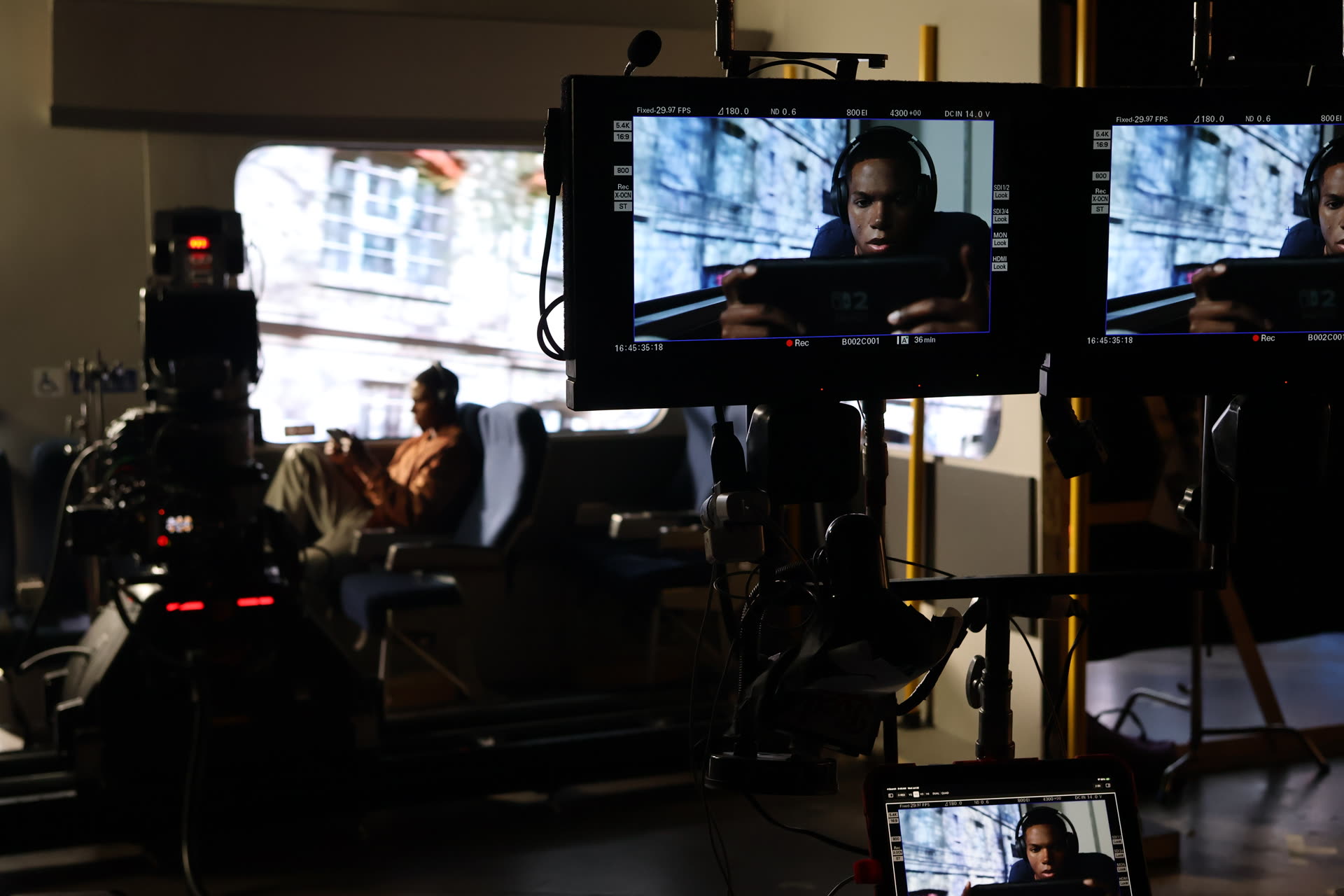 Monitors on set showing the bus shot as captured in camera, with the practical set and LED wall visible behind