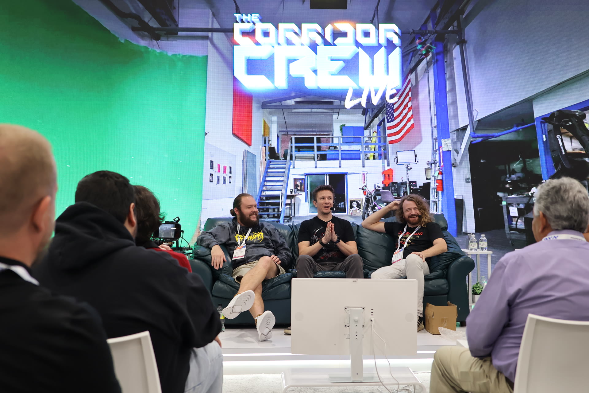 The Corridor Crew on stage at the Puget Systems booth, with the Corridor Crew LIVE backdrop