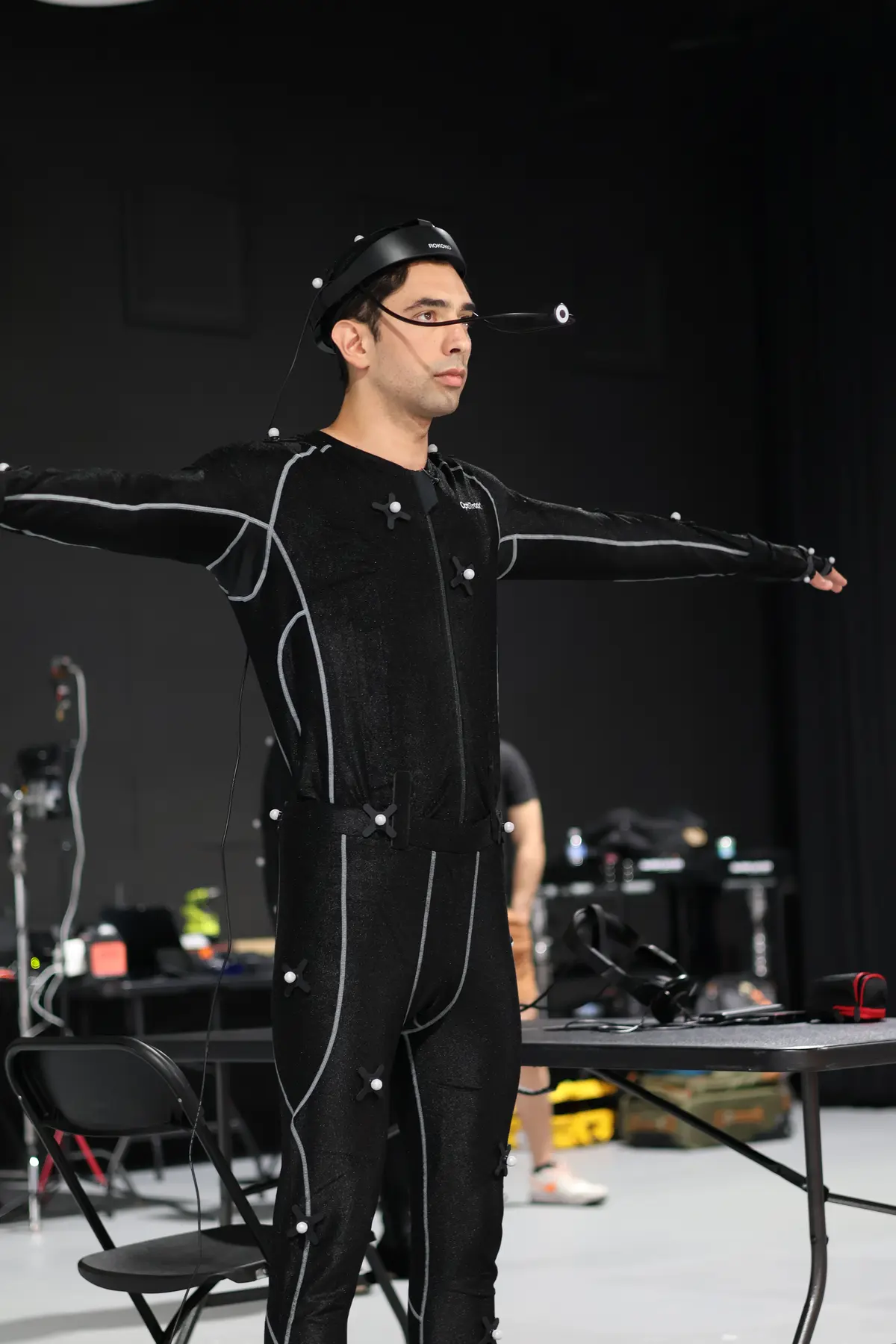 Performer in full motion capture suit with markers and head-mounted camera