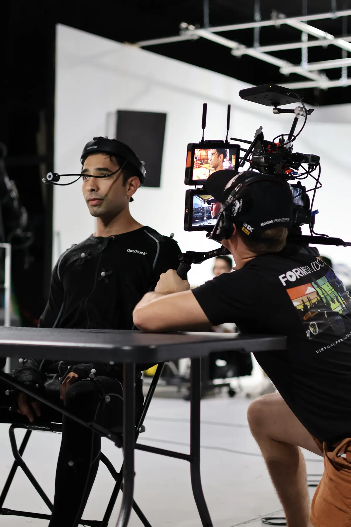 Performer in mocap suit being directed on capture stage